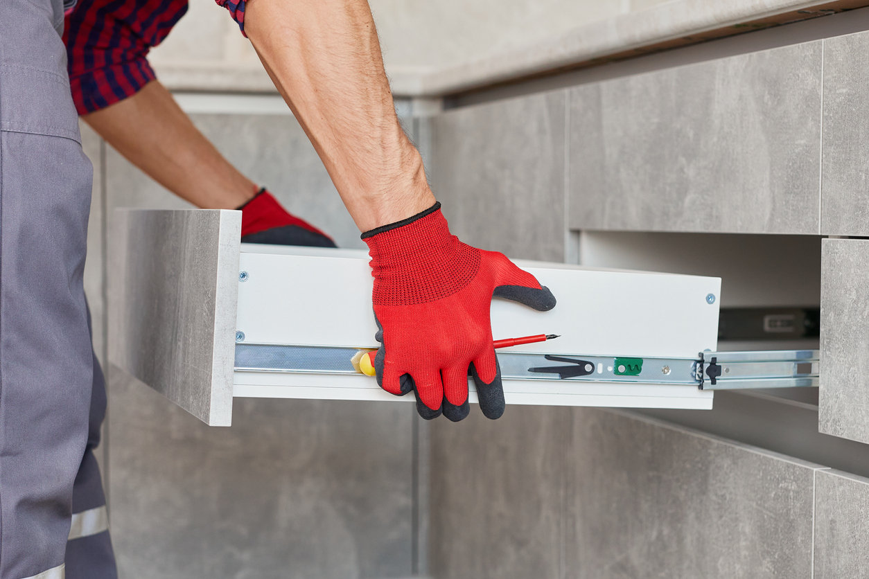 Carpenter installing kitchen cabinent drawer