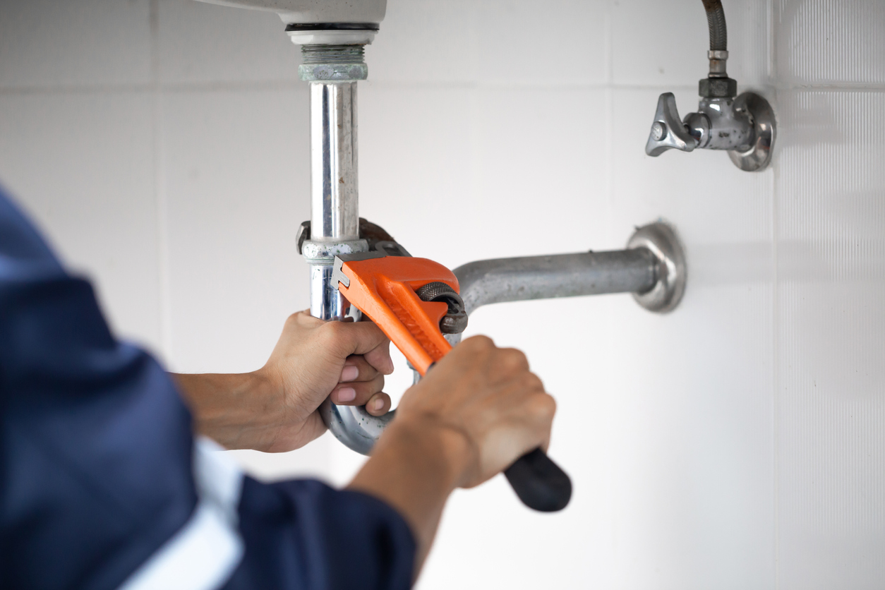 Plumber working on pipes